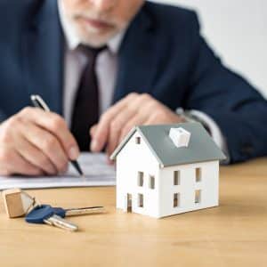 selective focus of house model near keys and house dealer